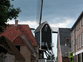 view of a windmill through an alley in Heusden, NL